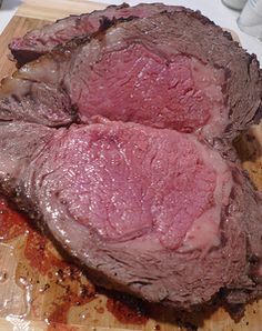 two pieces of meat sitting on top of a cutting board