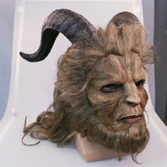 a mask with horns and long hair on top of a table