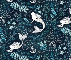 a blue and white fabric with mermaids, stars and seaweed on the bottom