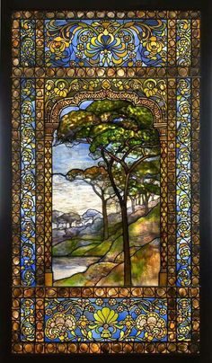 a stained glass window with trees and water