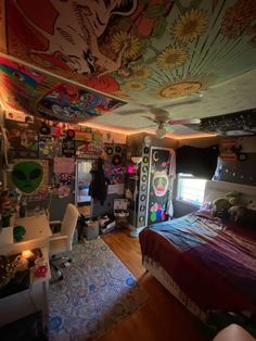 a bedroom with a bed, desk and ceiling covered in colorful wallpapered designs