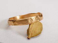 This handmade gold ring has a rough textured surface and a hammered finish. It is a slim band that is elegant and minimalistic. Made from solid 18k gold this ring has an impressive yet subtle personality and make an interesting statement!  My unique language uses raw material and a human touch, emphasising texture and simplicity, to create an organic and primal feeling in every piece. I combine the organic and primitive with the aesthetic becoming a creation with classic style embracing harmony, proportions, and beauty.  If you are looking for classic pieces of fine jewelry with a unique personal touch, you are in the right place.  ◈ DETAILS Model number: RMY640 Weight: about 1.5-2g  Width: 2 - 3.2 mm  Thickness: 0.6 - 0.9 mm  ◈ MATERIAL 18k solid yellow gold  ◈ ALSO AVAILABLE IN  14K in y Textured Wedding Ring, Minimalist Gold Ring, Textured Gold Ring, Texture Jewelry, Jewellery Aesthetic, Unique Gold Rings, Hammered Gold Ring, Gold Ring For Women, Handmade Gold Ring