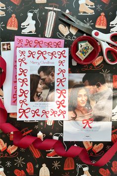 a couple's christmas card surrounded by red ribbon and scissors