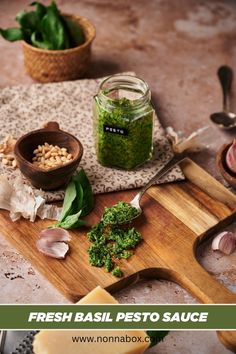 fresh basil pesto sauce on a cutting board next to garlic, parsley and other ingredients