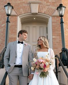 a bride and groom are standing on the steps