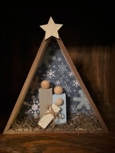 a christmas tree made out of wood and other items in a wooden box with snowflakes on it