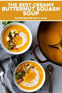 two bowls of creamy butternut squash soup on a table with spoons and silverware