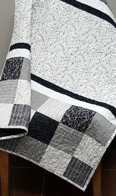 a black and white quilt sitting on top of a wooden table