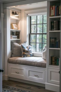 a window seat in the corner of a room with bookshelves on either side