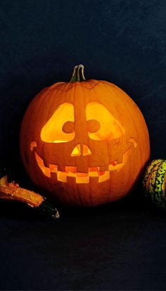 a carved pumpkin with the word kurbisse in front of it and other halloween decorations around it