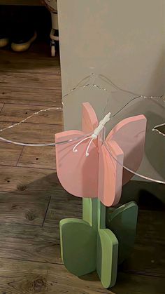 a paper flower sitting on top of a wooden floor