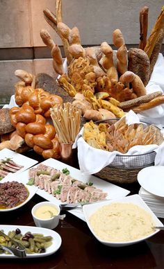 many different types of breads and other food items on a table with napkins