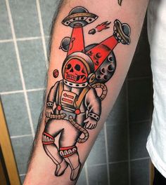 an astronaut tattoo on the arm with skulls and rockets in space around him, as if he is flying through the sky