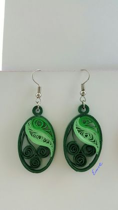 the earrings are made out of paper and have swirly designs on each earring