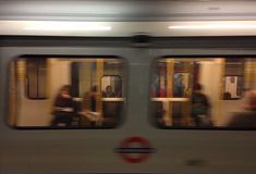 people are sitting on the subway train as it's moving through the city at night