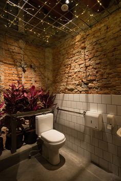 a bathroom with brick walls and lights above the toilet