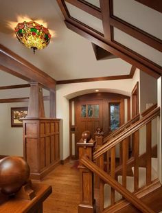 an entry way with wooden stairs and glass chandelier