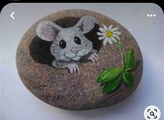 a rock painted with a mouse and a flower