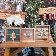 three wooden snowflakes are sitting on a table in front of a christmas tree