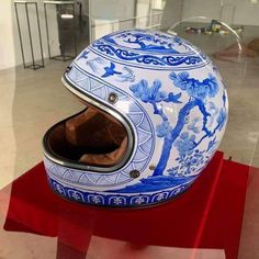 a helmet is on display in a glass case with red stand holding it up to the side