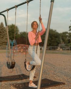 a woman is sitting on a swing set