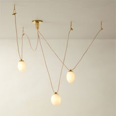 three light fixtures hanging from the ceiling in a room with white walls and flooring