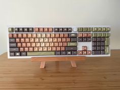 a computer keyboard made out of chocolates on top of a wooden table next to a white wall