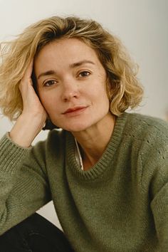 a woman sitting down with her hand on her head