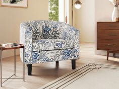 a blue and white chair sitting on top of a wooden floor next to a table