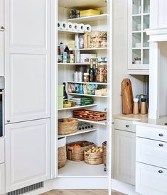 an open pantry in a white kitchen with lots of cupboard space and items on the shelves