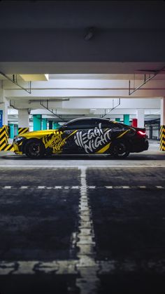 a car parked in a parking garage with yellow and black stripes painted on the side