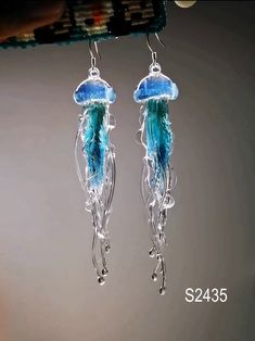 a pair of jellyfish earrings hanging from a hook