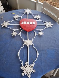 a cross with the word jesus on it sitting on top of a blue table cloth