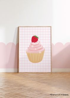 a strawberry cupcake with pink icing and sprinkles is displayed in front of a white wall