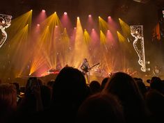 a group of people that are standing in front of a stage with lights on it