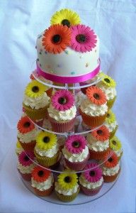 cupcakes are stacked on top of each other in front of a multi - tiered cake