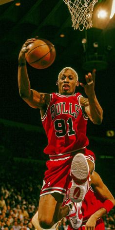 a basketball player jumping up into the air to dunk a ball in front of him