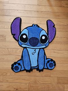 the rug is shaped like a cartoon character with big eyes and ears, sitting on a wooden floor