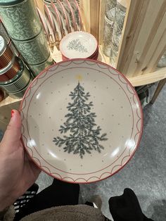 a person holding a plate with a christmas tree on it in front of other plates