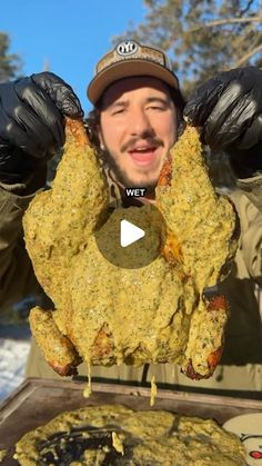 a man holding up a large piece of meat in front of him with gloves on