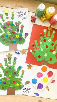 three handprints are displayed on a table with paint and paper, along with other crafting supplies