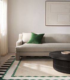 a living room with a white couch and green pillows