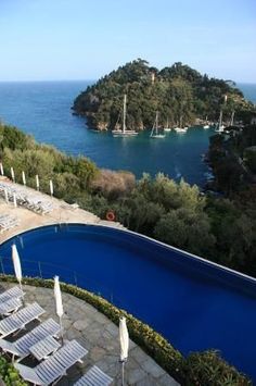 an outdoor swimming pool surrounded by trees and water