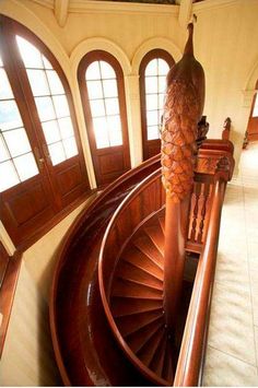 an aerial view of a spiral staircase in a house with large windows and arched doors