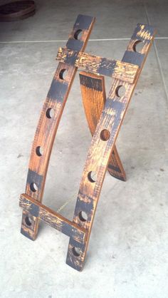 an old wooden chair sitting on top of a cement floor with holes in the wood