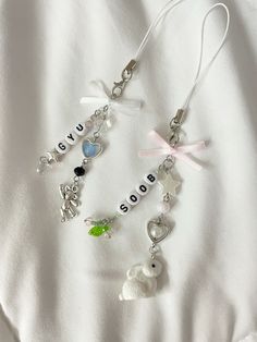 two necklaces with charms that spell out love