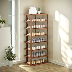 a wooden shoe rack with many pairs of shoes on it in the corner of a room