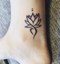 a small lotus tattoo on the ankle