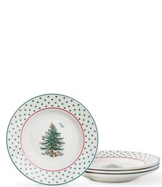 three white plates with green and red trimmings, one has a christmas tree on it