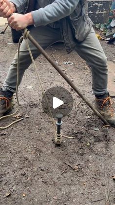 a man kneeling down while holding a pole